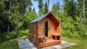 Sauna extérieur en cèdre rouge style chalet rustique en bois dans un jardin